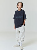 Full front view of child wearing navy Kids Classic Short Sleeve Tee with subtle Fear of God Essentials print, gallery position 0