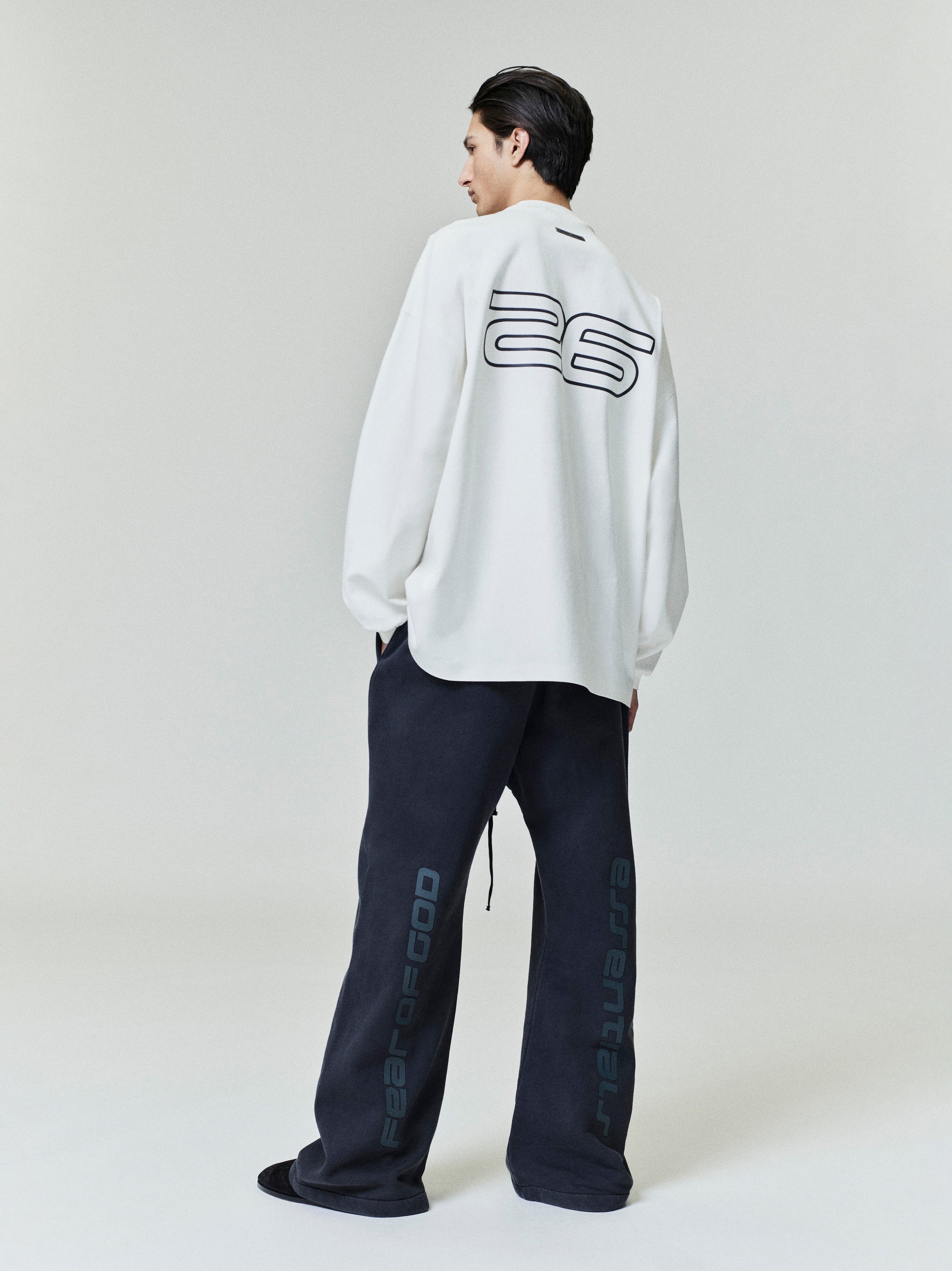 Model wearing black Heavy Fleece Flare Sweatpant with side vertical script, paired with oversized white long sleeve shirt, gallery 0