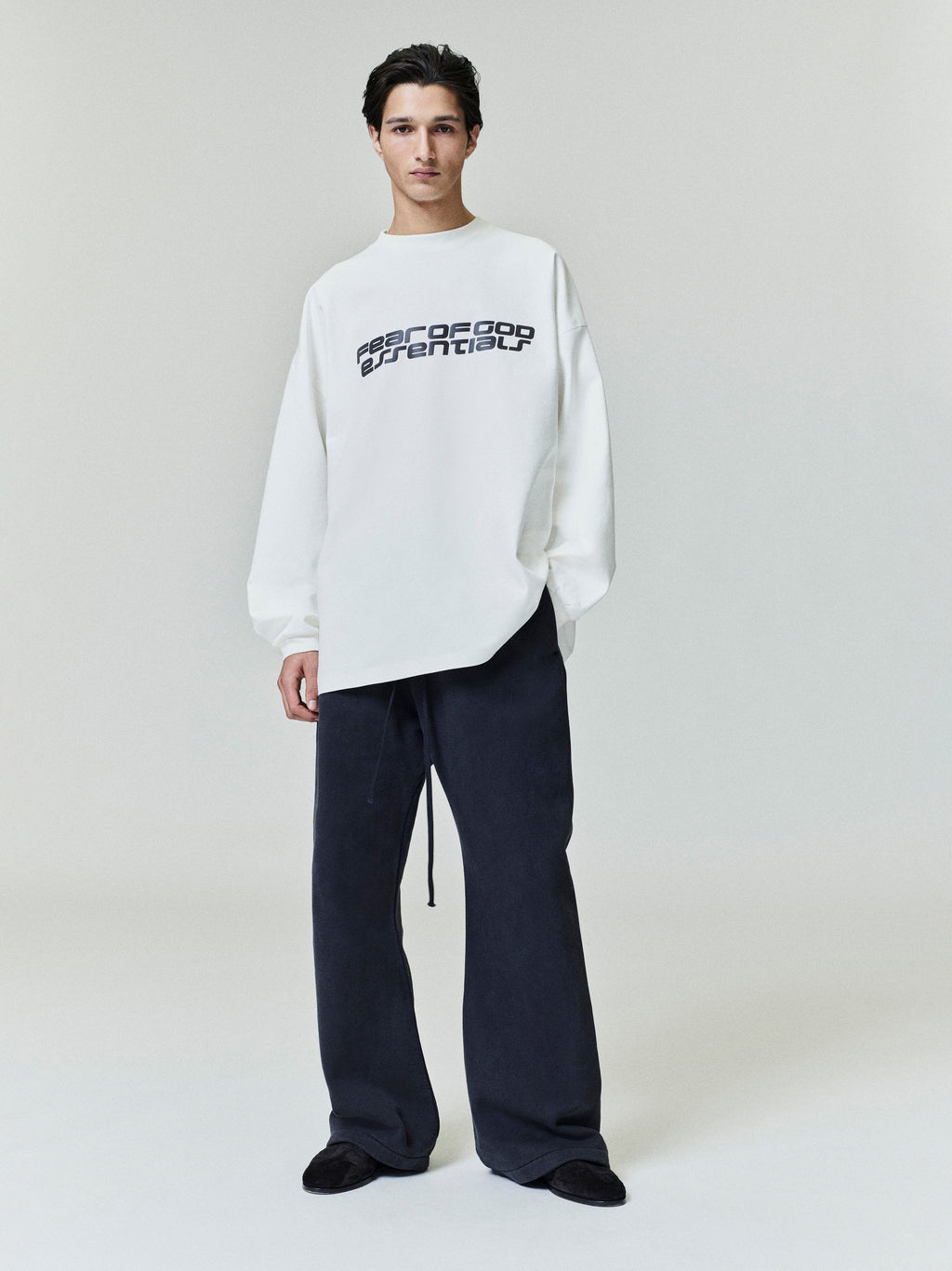Model wearing white Ponte 90s Long Sleeve Tee with bold logo across chest, styled with loose dark pants, gallery 0 0014_HO25_F_L80_4311.jpg