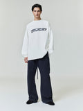 Model wearing white Ponte 90s Long Sleeve Tee with bold logo across chest, styled with loose dark pants, gallery 0 0014_HO25_F_L80_4311.jpg