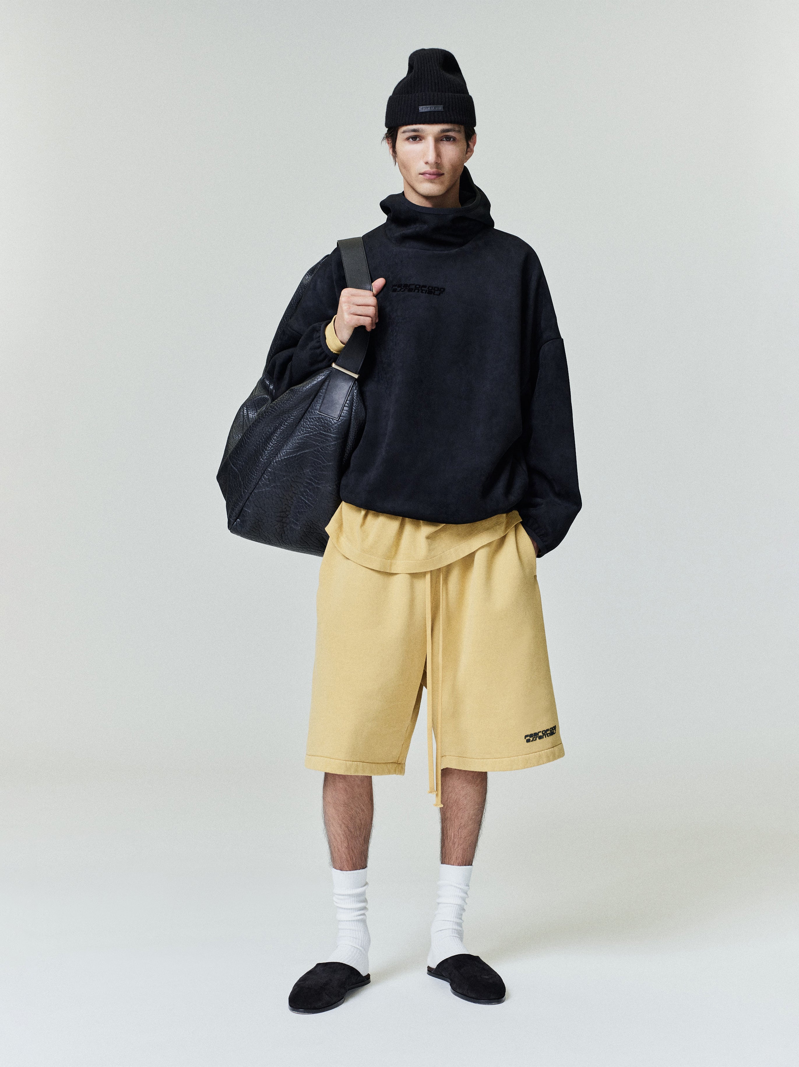 Model wearing black suede fleece modern hoodie with high funnel neck and loose fit, file 0020_HO25_F_L19_2284_OnModelImage.jpg