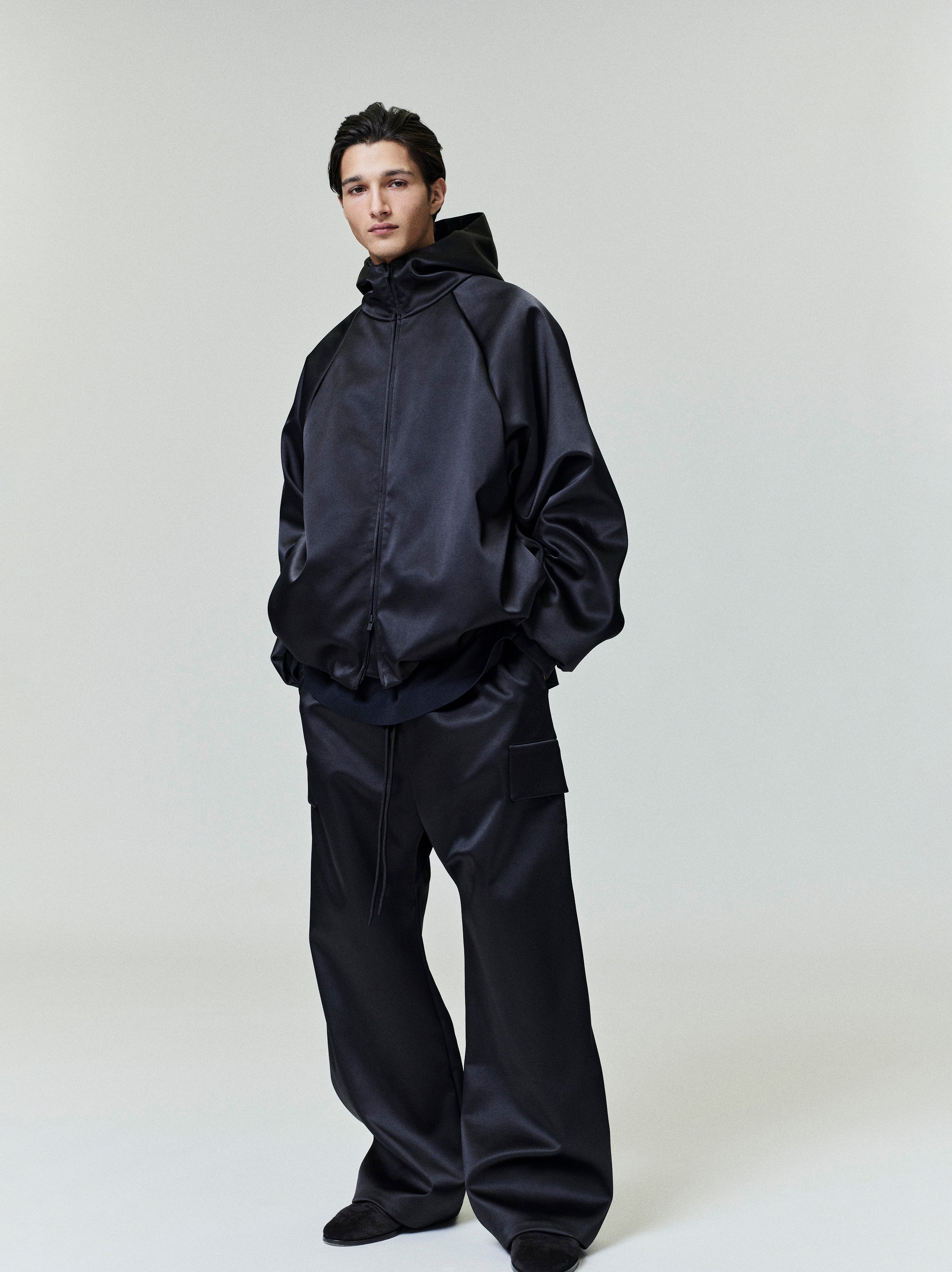 Model standing wearing black Bonded Satin Field Pant with wide leg and side cargo pockets, gallery 0, file 0026_HO25_F_L77_P40_4081.jpg
