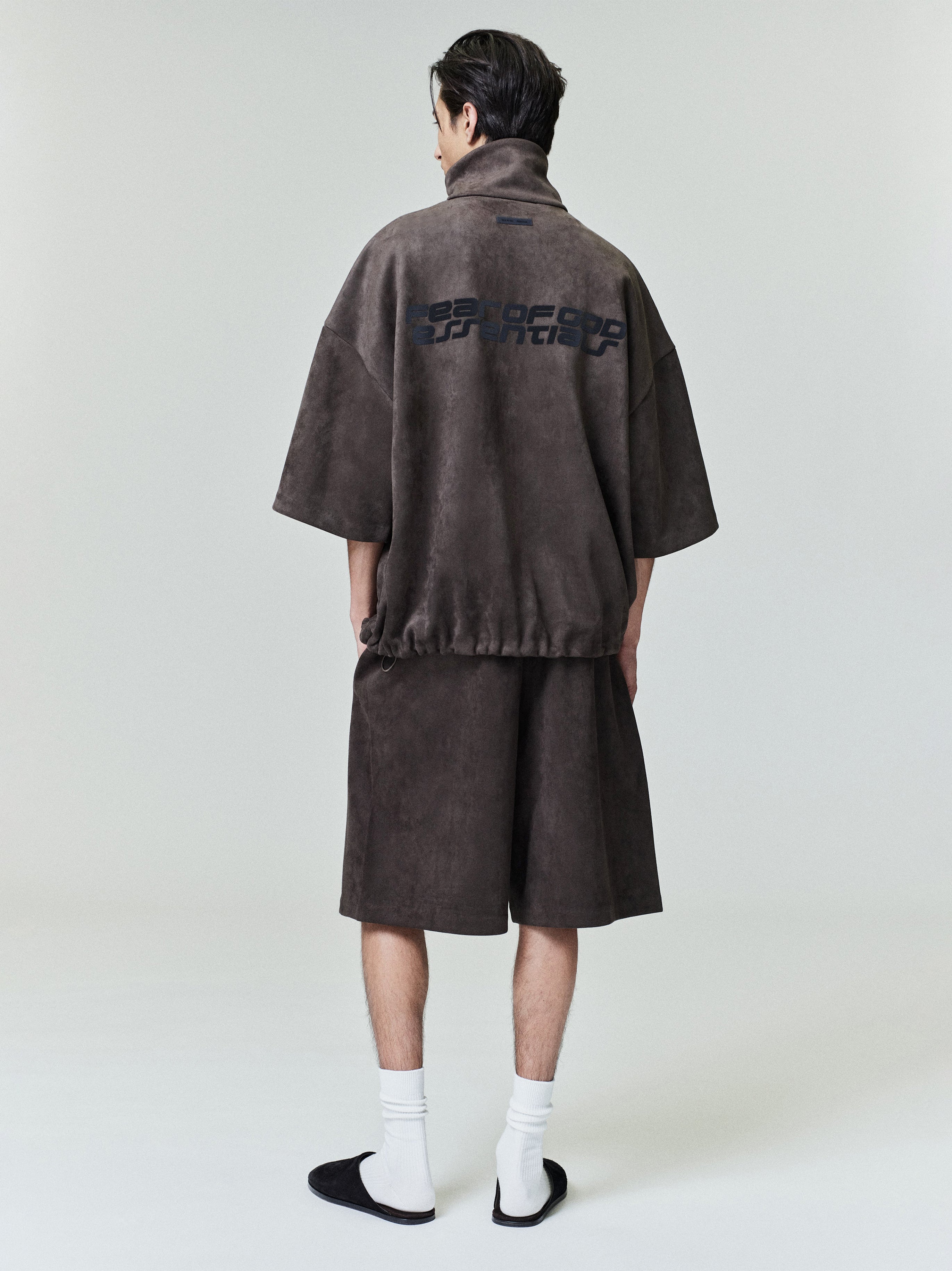 Male model shown from back wearing brown Suede Fleece Relaxed Short and matching half-zip top with graphic print on back