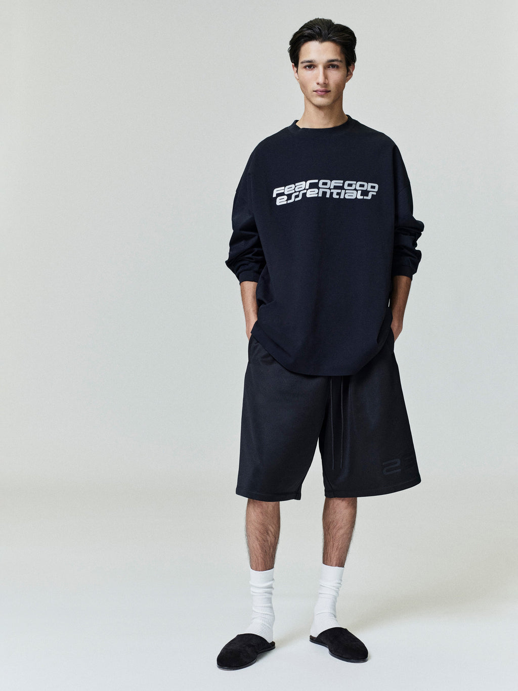 Model wearing black Ponte 90s Long Sleeve Tee with white Fear of God Essentials logo centered, standing straight, gallery 0028_HO25_F_L41_P01_0889copy.jpg