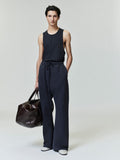 Model wearing vintage black Embroidered Essential Tank with relaxed pants and large leather duffle bag, gallery image 0