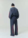 Model showcasing back view of slate gray Heavy Fleece Flare Sweatpant with red vertical script on legs and sleeves, gallery 0