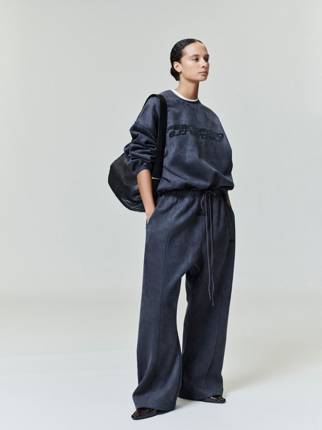 Model wearing dark charcoal Suede Fleece Modern Crewneck Sweatshirt and wide-leg pants in studio shot 0040_HO25_FW_L37_0424.jpg