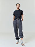 Woman wearing dark grey Womens Classic Sweatpant with beige drawstrings and elastic cuffs, styled with a black tee, gallery 0 0040_HO25_FW_L57_2499.jpg