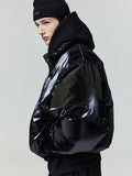 Profile of model wearing glossy black ripstop nylon puffer jacket with high collar and knit beanie, gallery position 0