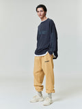Model wearing navy 90s Long Sleeve Tee with subtle branding on chest and sleeve, styled with tan sweatpants, gallery 0.