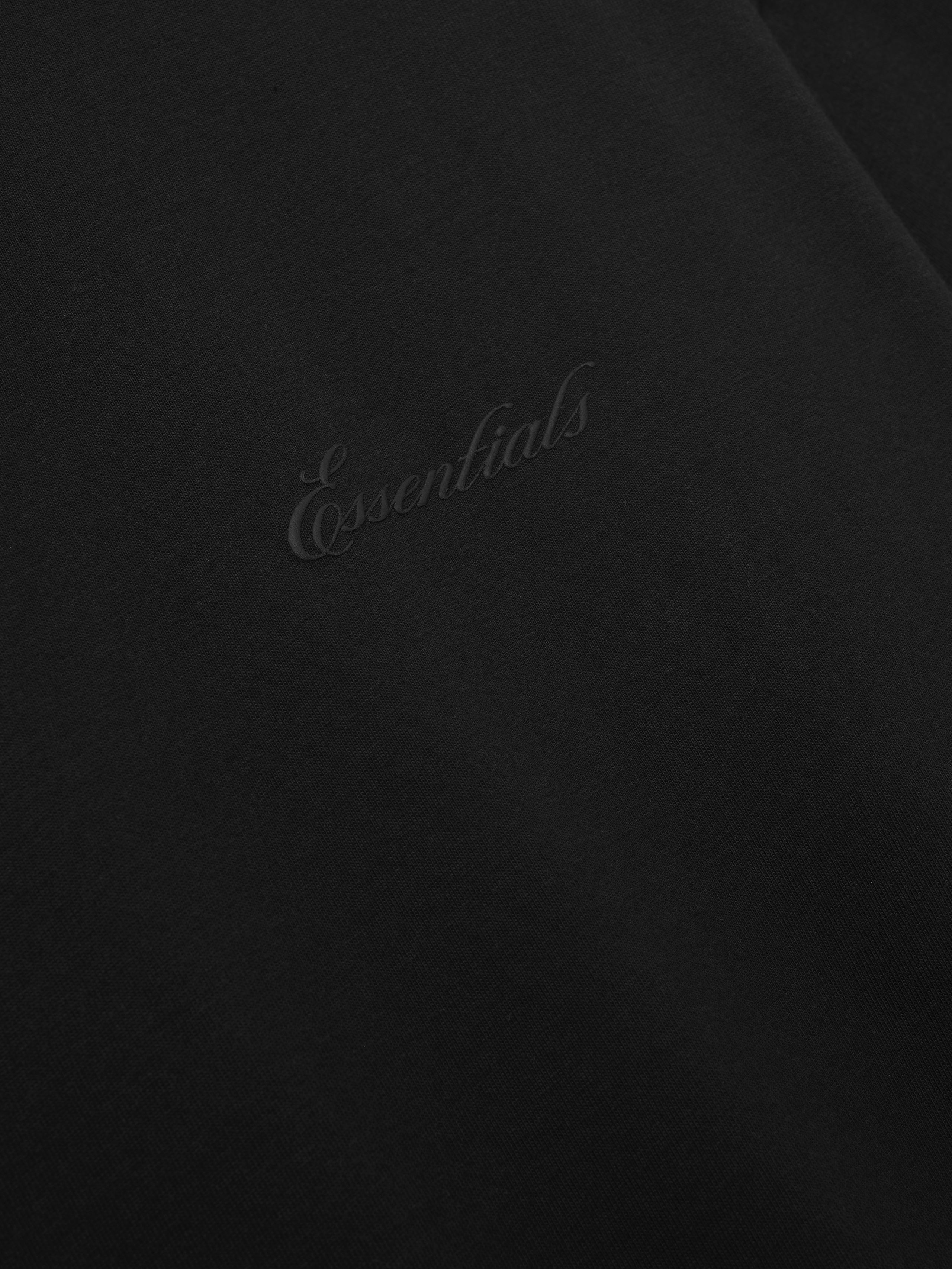 Black tee with 'Essentials' embroidery on a black background