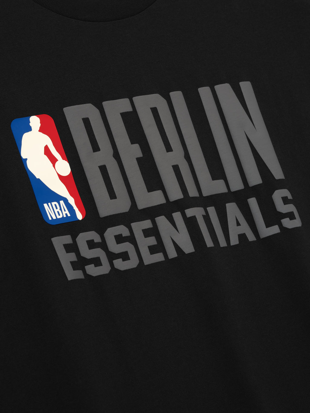 Close-up of black Berlin 90s Fit Tee showing grey BERLIN ESSENTIALS text and colorful NBA logo, file 125EU264201F, gallery 0