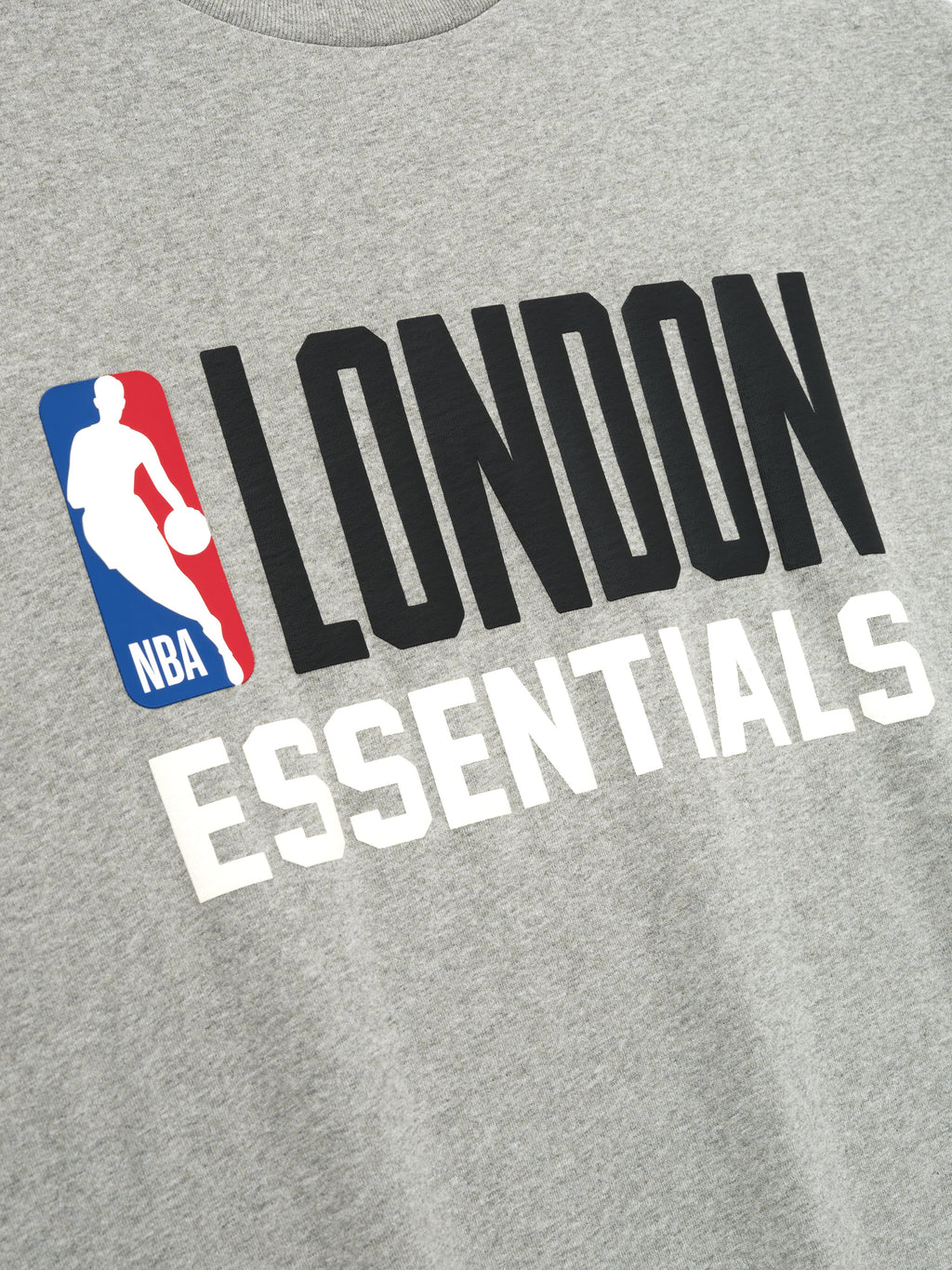 Close-up of concrete heather fabric with bold black LONDON and white ESSENTIALS text and NBA logo on front of tee, file 125EU264202F