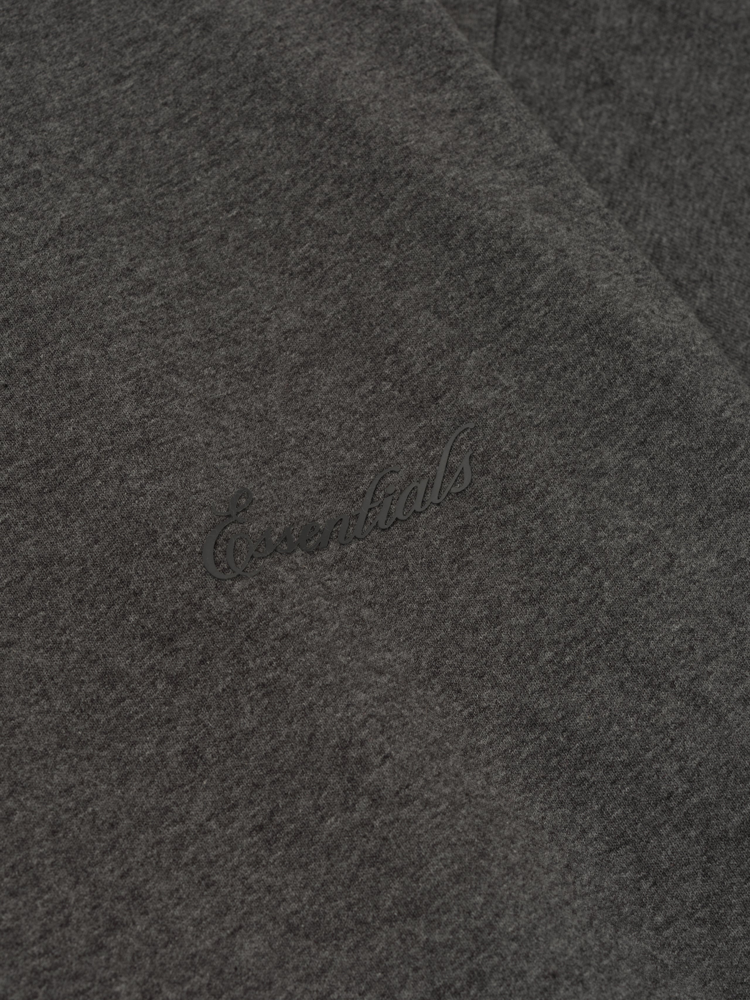 Close-up of charcoal heather Embroidered Classic Short Sleeve Tee showing subtle tonal Essentials logo on soft fabric