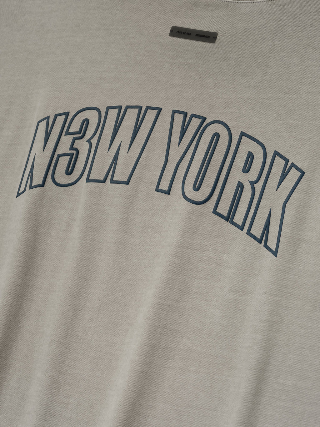 Close-up of smoke grey New York 90s Tee featuring bold navy N3W YORK print on soft cotton fabric