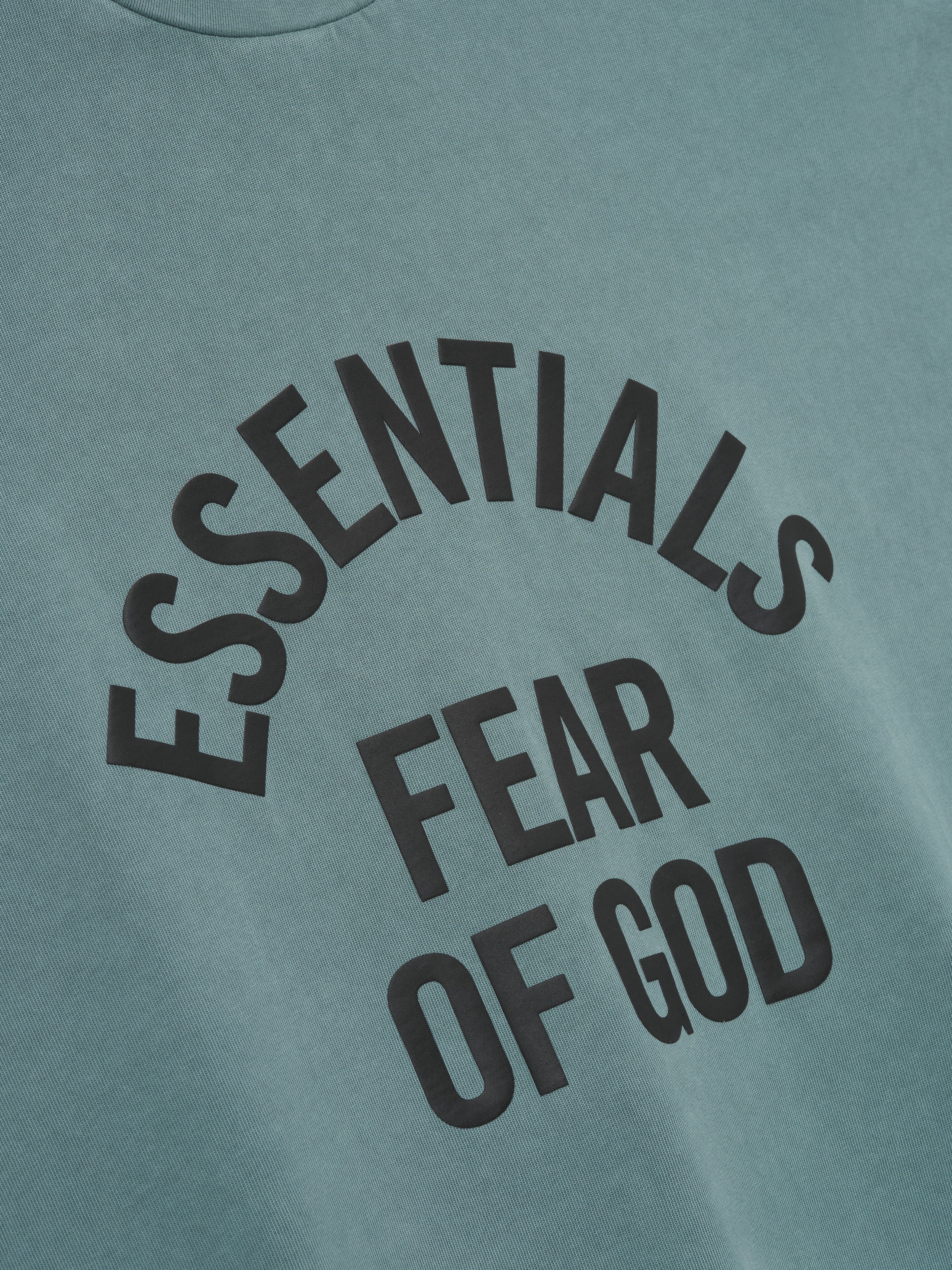 heavyweight pigment-dyed cotton long sleeve tee in faded teal with curved ESSENTIALS FEAR OF GOD text front
