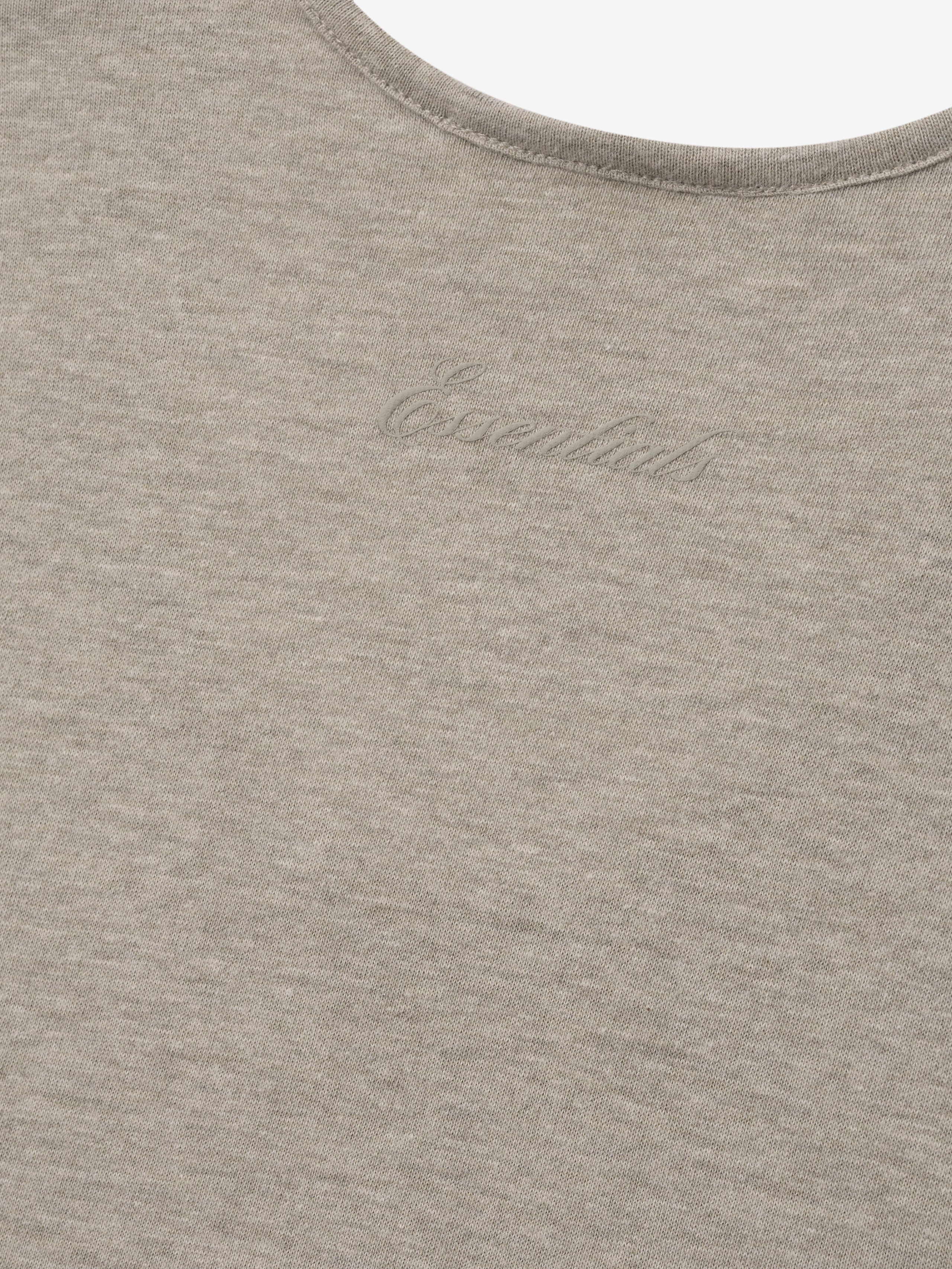 close-up of lightweight taupe tri-blend fabric with subtle embossed Essentials logo on Signature Essential Tank top