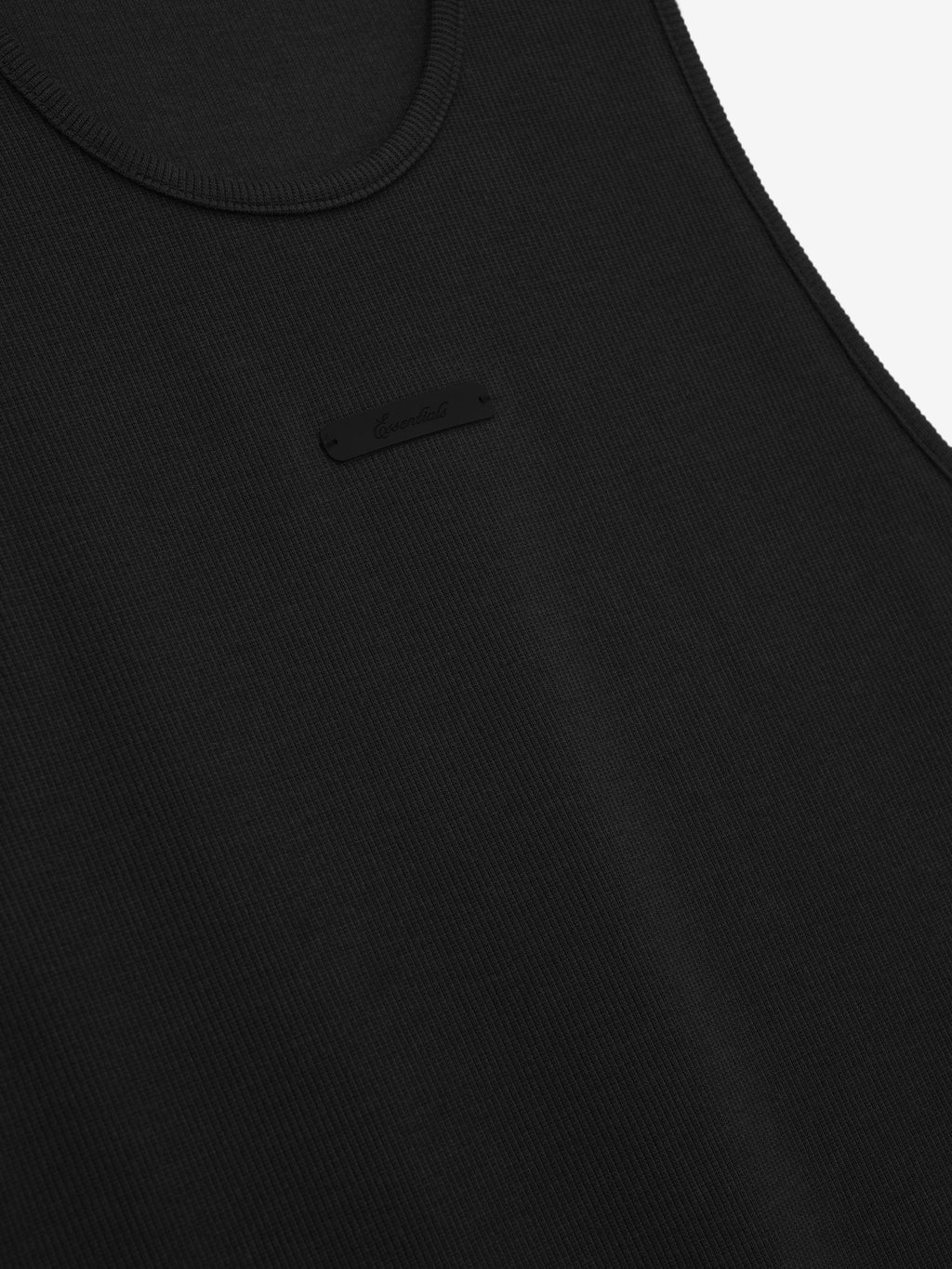 close-up of black ribbed cotton spandex tank top with U-neck and subtle Essentials signature la branding on chest
