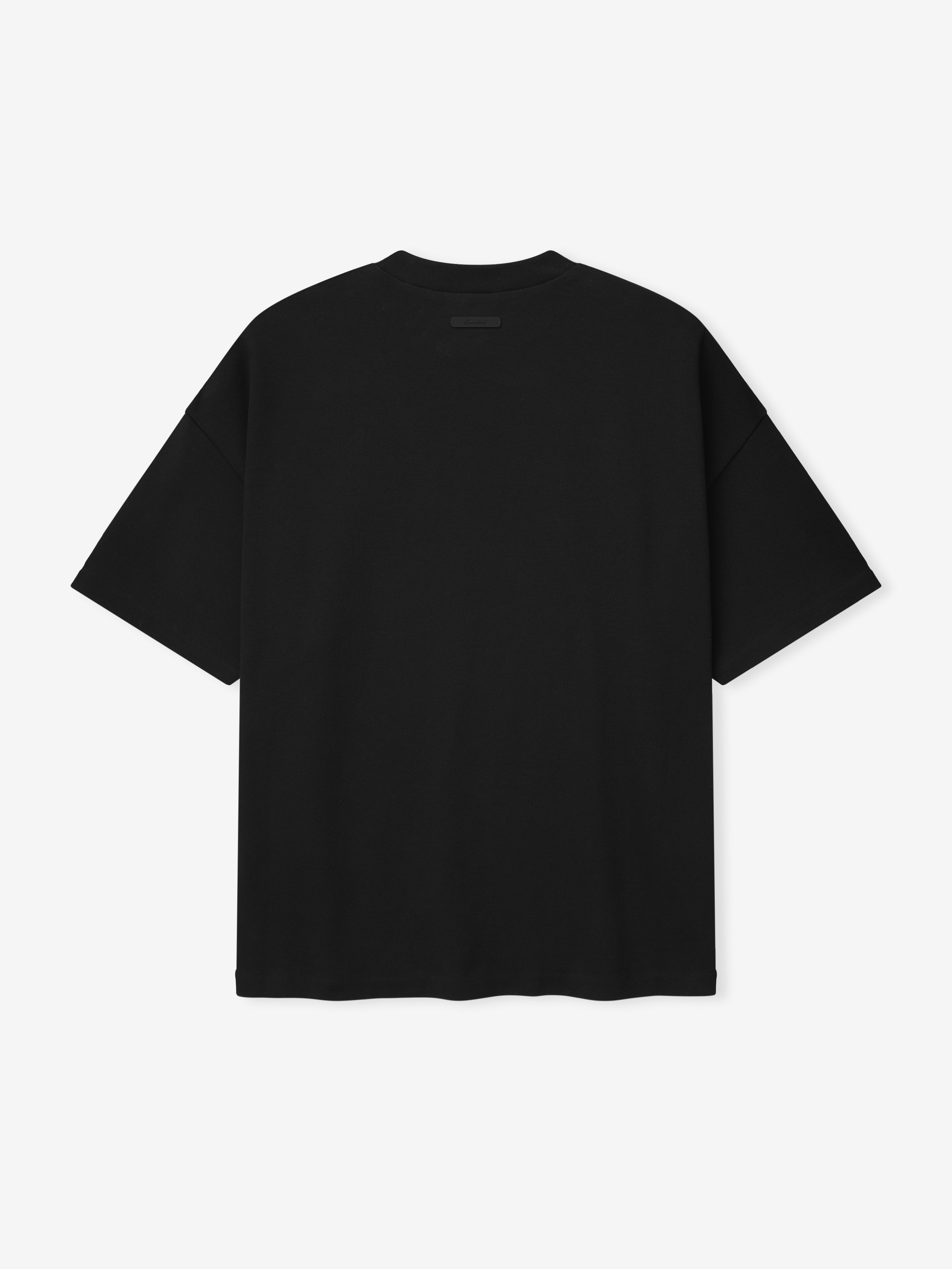 back view of black medium-weight cotton poly pique knit tee with oversized 90s fit and dropped shoulders