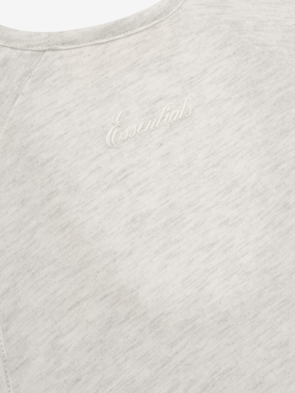 Close-up of a textured gray tank with Essentials script.