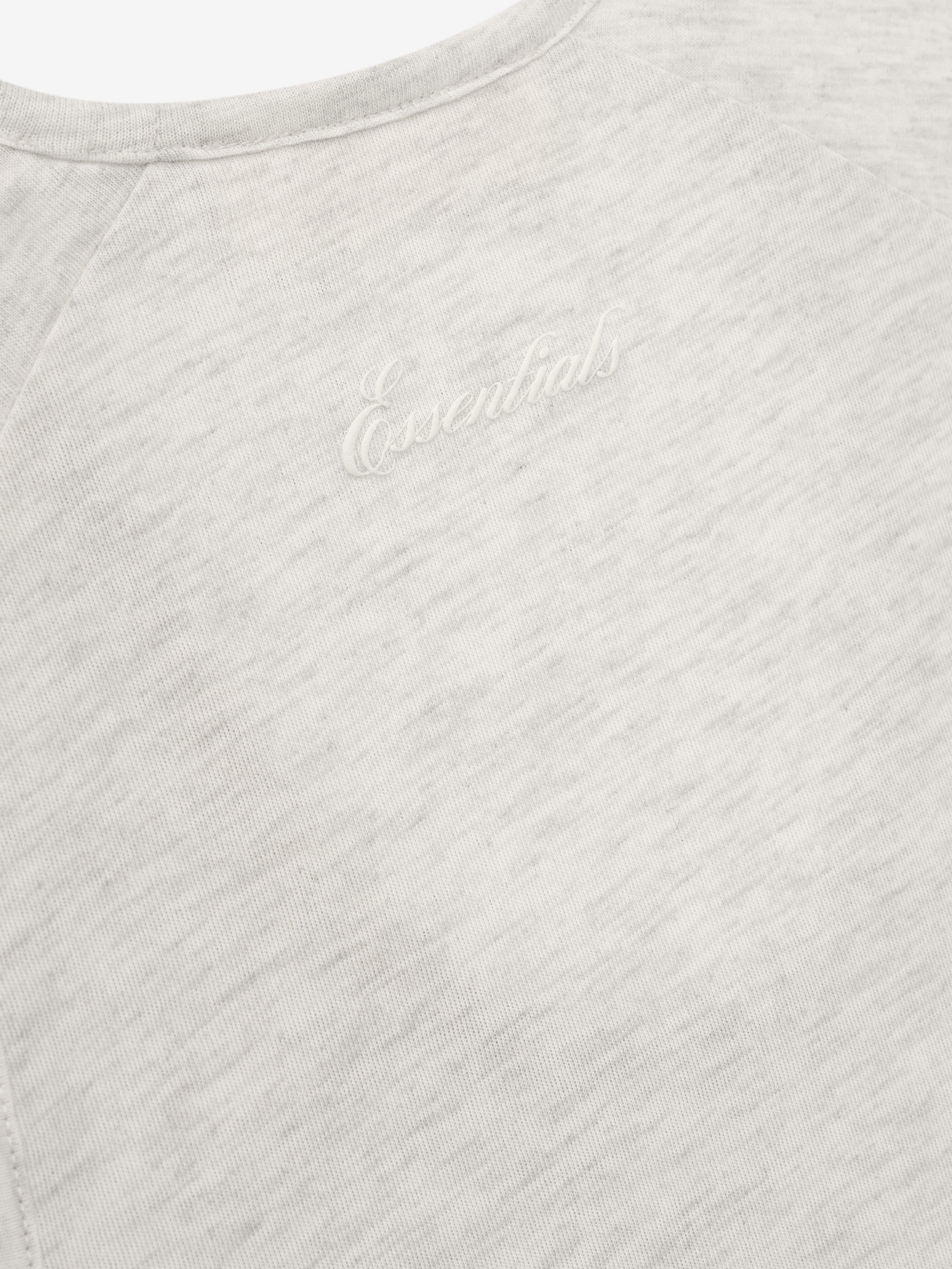 Close-up of a textured gray tank with Essentials script.