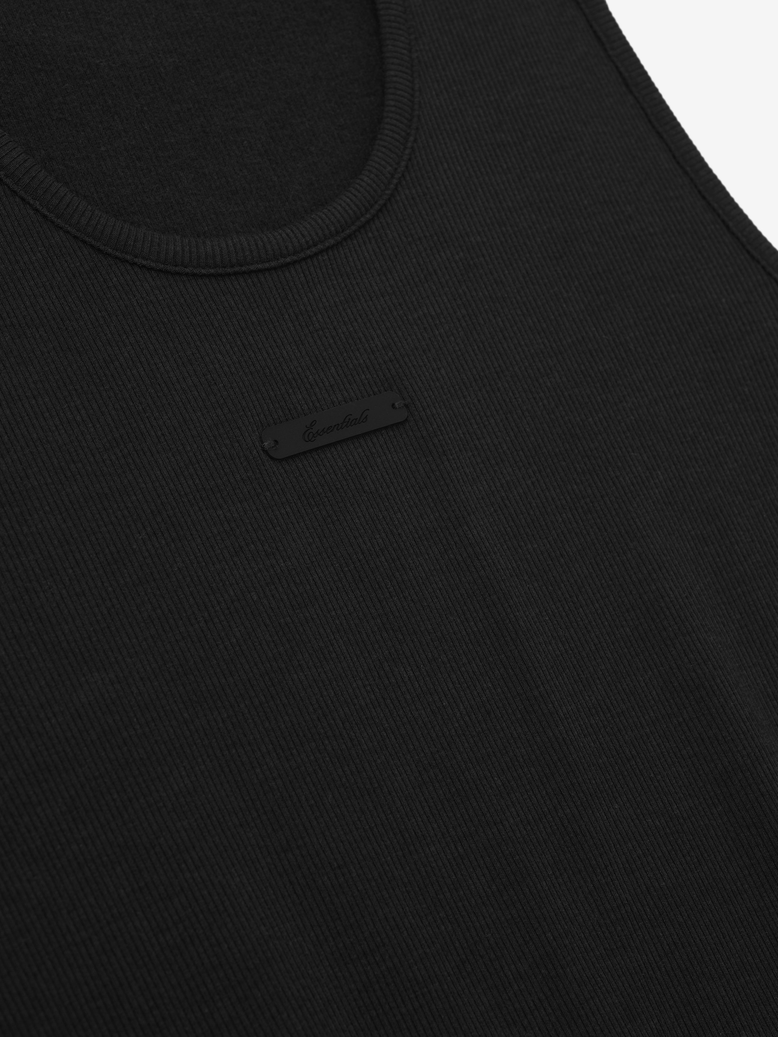 close-up of black rib knit cotton-rayon-spandex tank top with subtle branded rectangular patch at chest