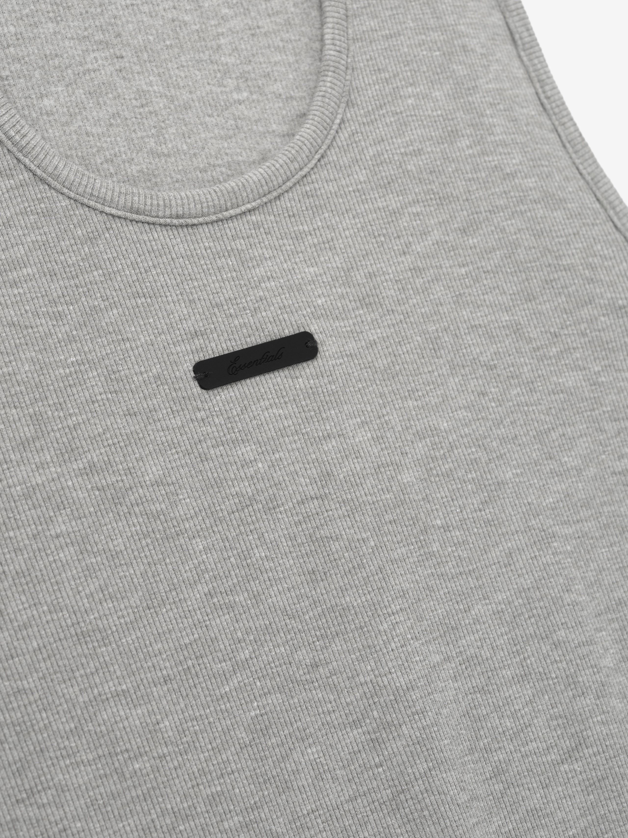 close-up of light gray ribbed cotton-rayon-spandex knit tank with U-neck and small black rectangular logo patch on chest