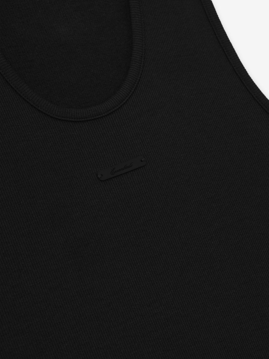 close-up of black ribbed knit fabric with small black rectangular brand label sewn on front neckline