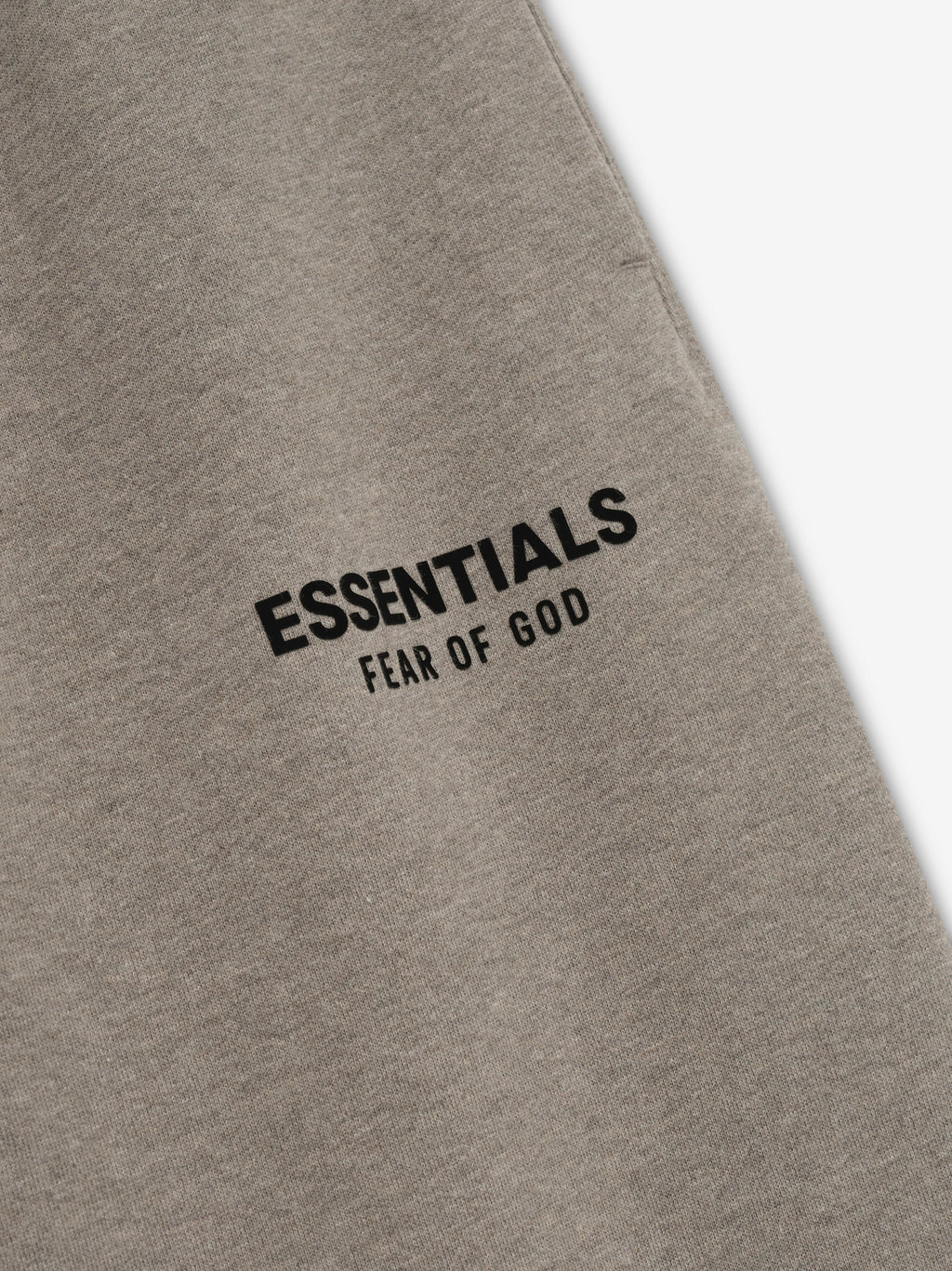 Gray sweatpants with 'Essentials Fear of God' text on a white background