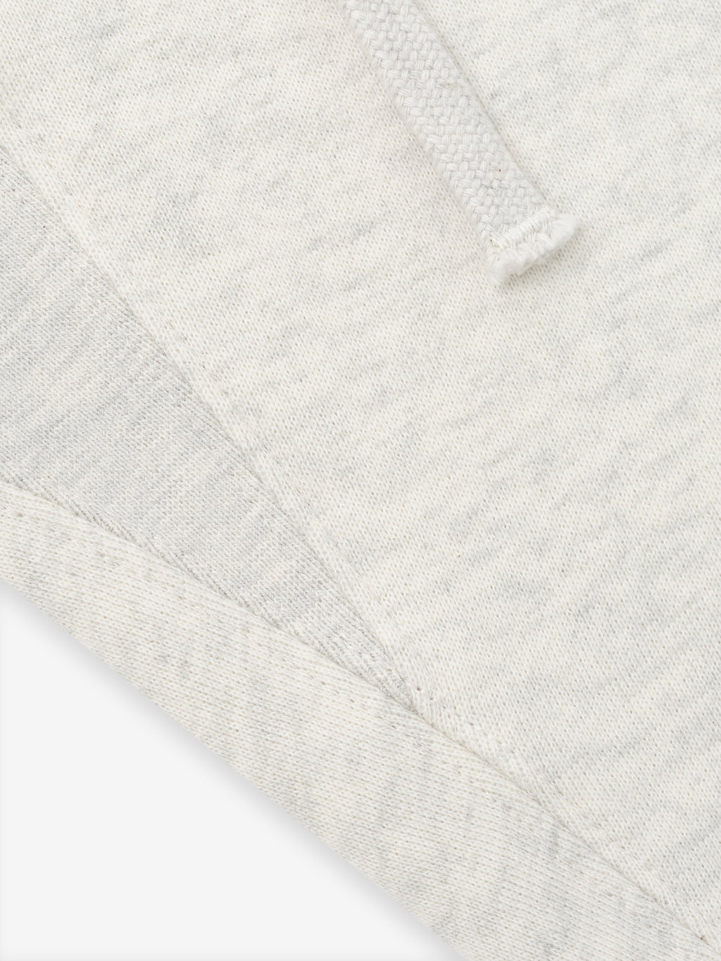 close-up of off-white fleece fabric with drawstring detail and visible seam on classic sweatpant waistband