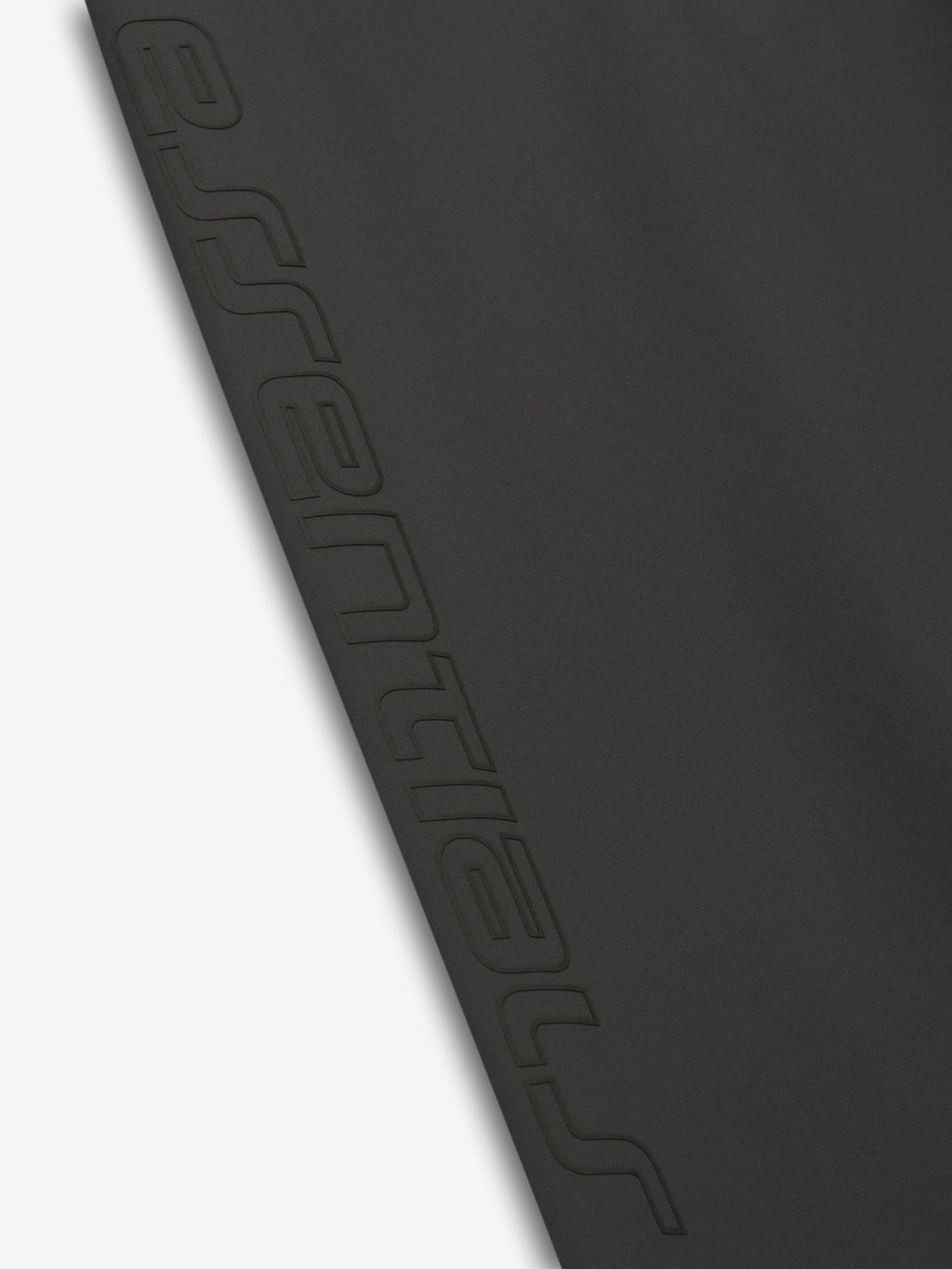 Close-up of iron grey Tech Nylon Relaxed Track Pant leg showing embossed Fear of God Essentials text detail