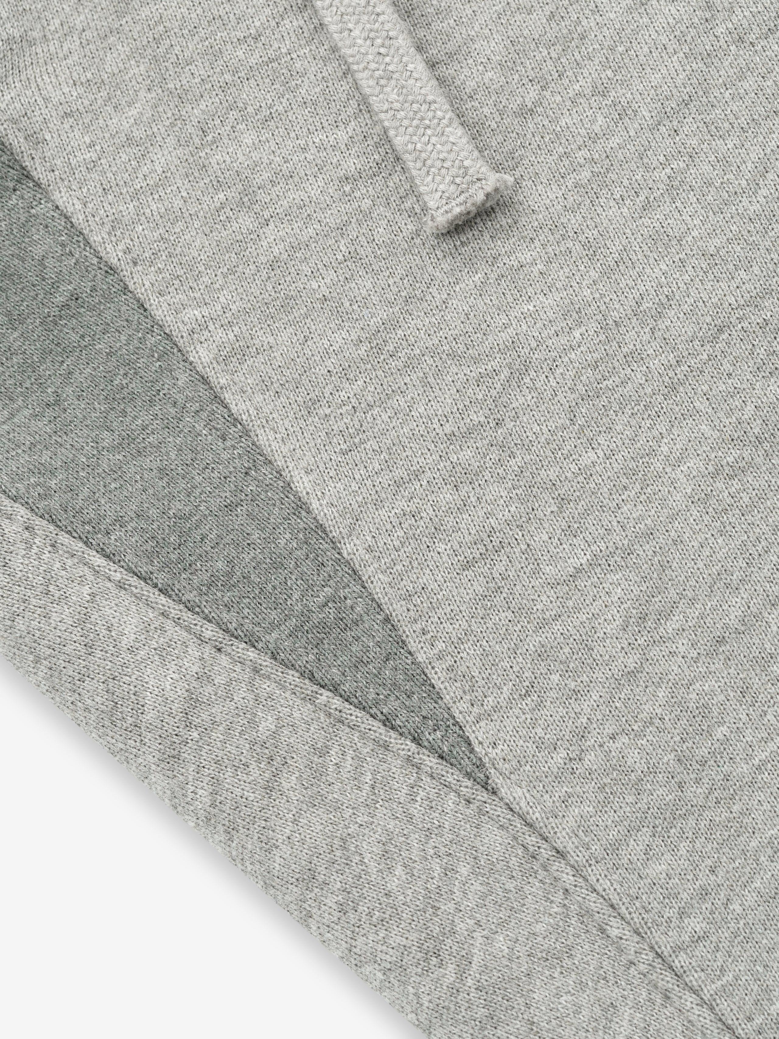 close-up of light grey core fleece fabric with stitched edges and drawstring detail on sweatpants