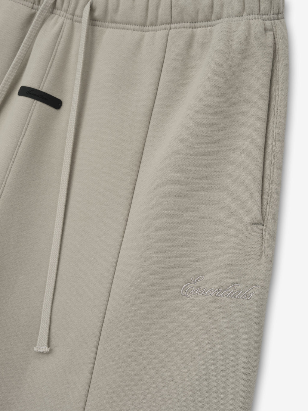 Grey sweatpants with an Essentials Signature logo on a white background