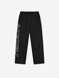 Black relaxed-fit pants with elastic waistband and vertical white "essentials" text on the side leg
