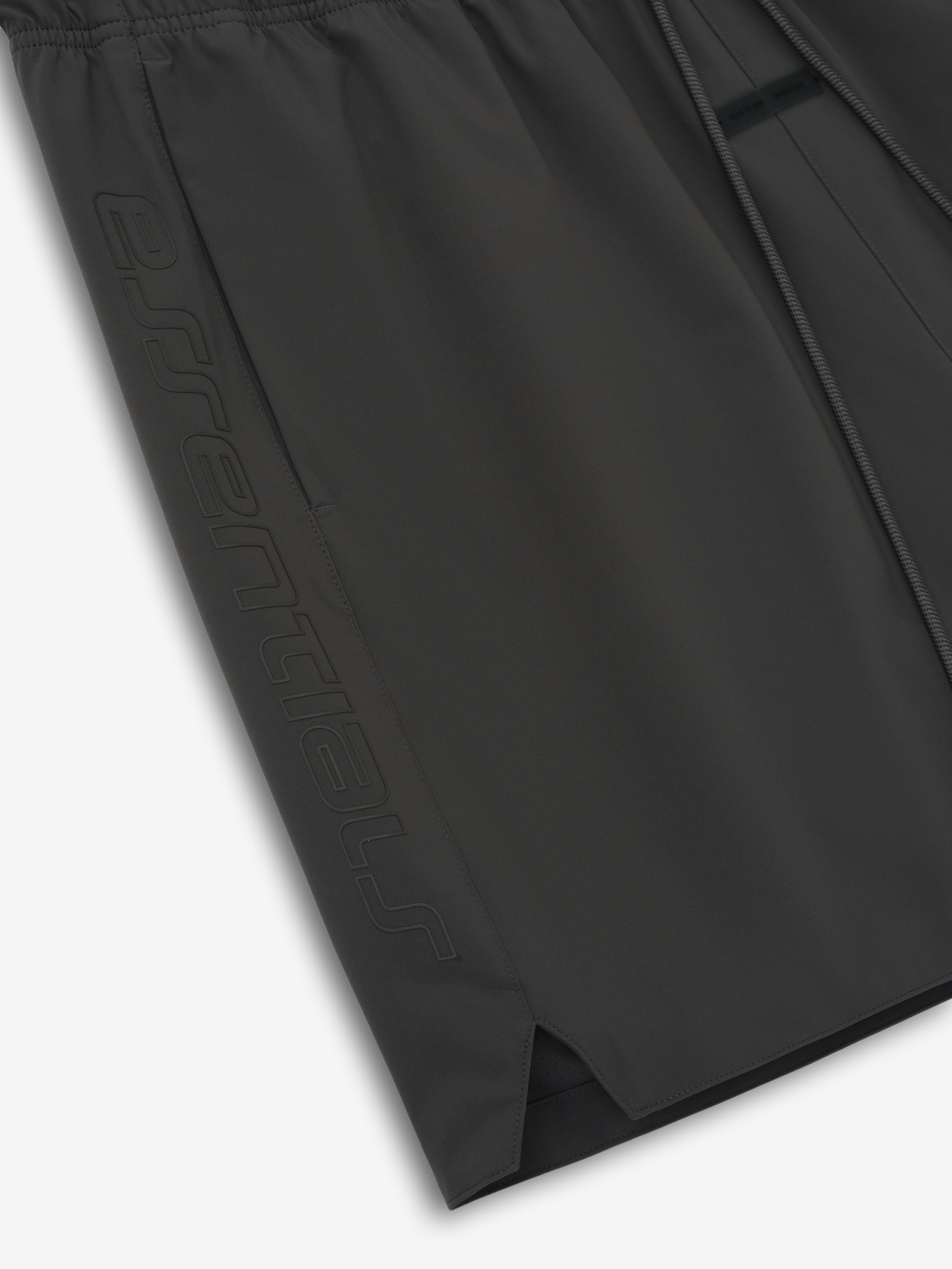 Close-up of iron grey Tech Nylon Classic Short showing embossed logo on side and elastic waistband detail