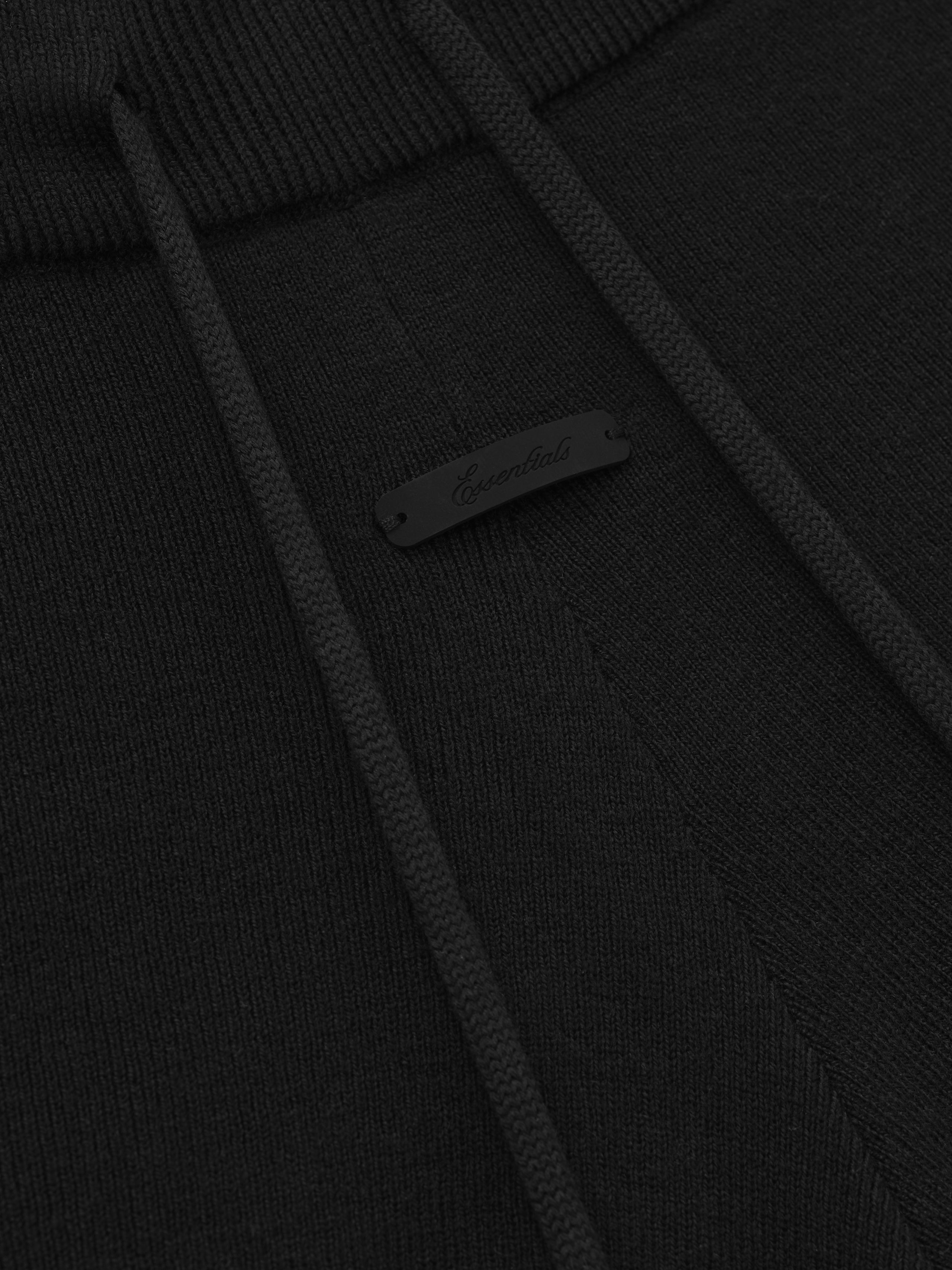 close-up of black rib knit fabric with drawstring and subtle branded tag detail on running shorts waistband