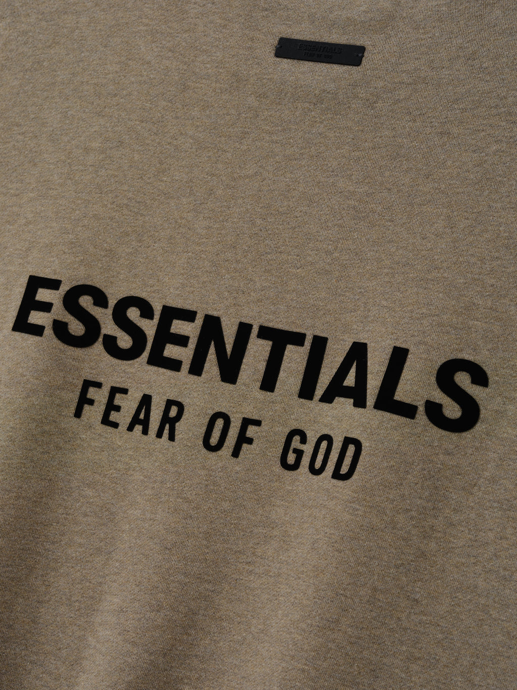 Close up of Homestead Heather sweatshirt with 'ESSENTIALS FEAR OF GOD' text logo