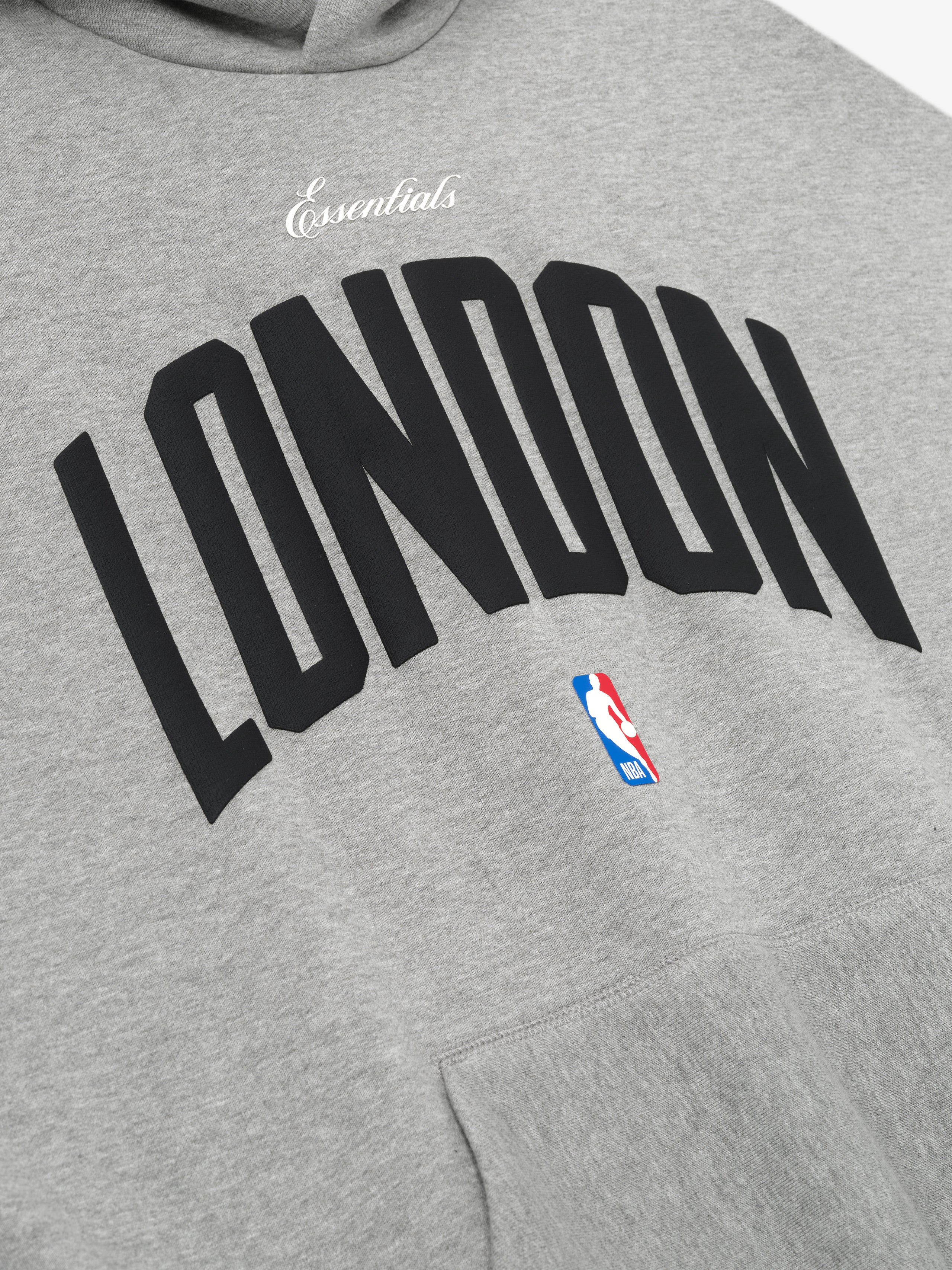 Close-up of concrete heather London 90s Hoodie showing "Essentials" script and NBA logo above front pocket, gallery 0.