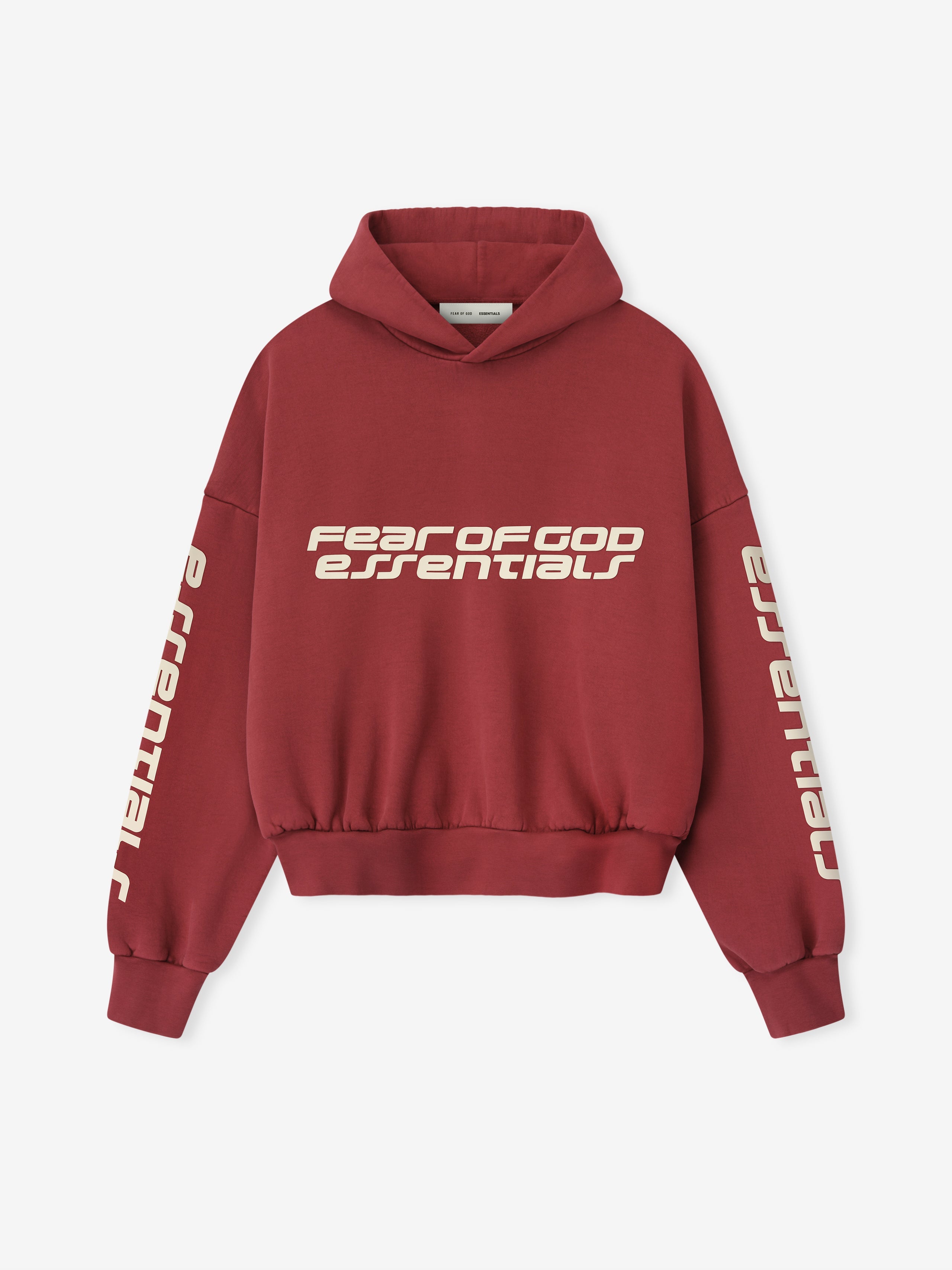 Front view of crimson cropped relaxed hoodie with cream Fear of God Essentials logo printed horizontally on chest and vertical on sleeves