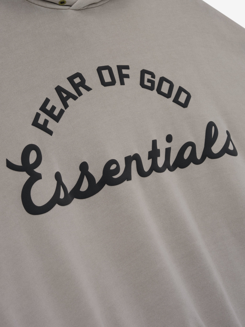 close-up of taupe cotton fleece hoodie with black puff-printed Fear of God Essentials logo on front