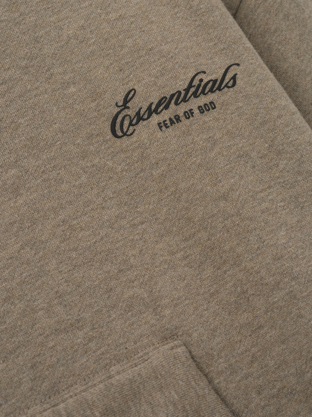 close-up of taupe core fleece fabric with black Essentials Fear of God logo printed on front chest panel