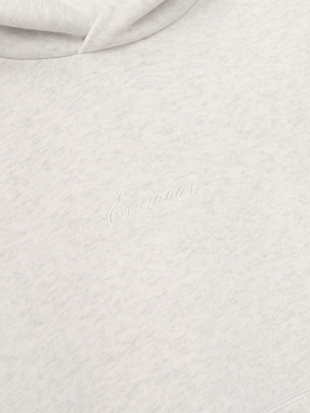 Close-up of textured white fabric with Essentials Embroidery