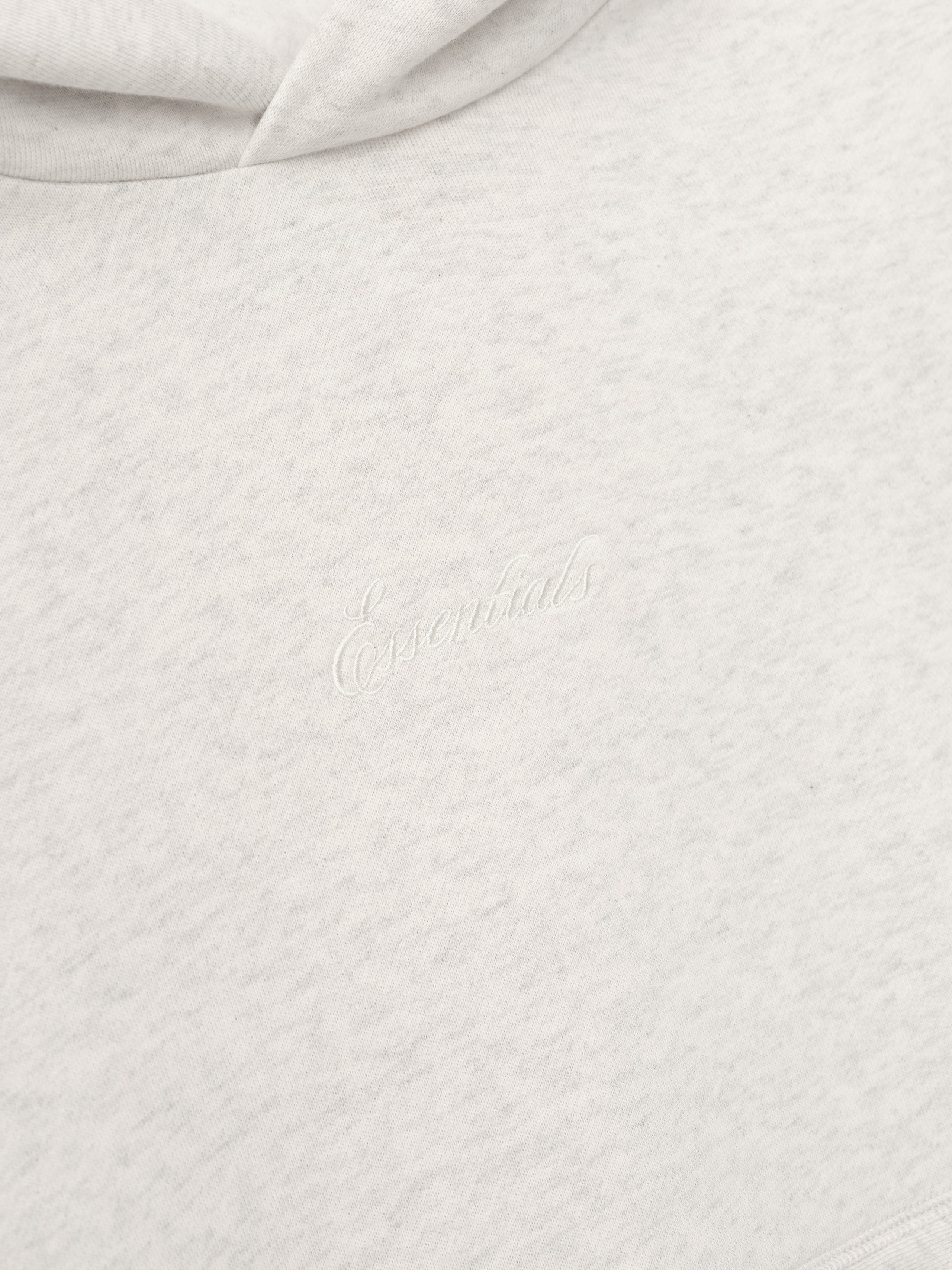 Close-up of textured white fabric with Essentials Embroidery