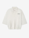 off-white heavy merino knit polo with 3/4 sleeves, relaxed fit, classic collar, and black Essentials script embroidery on chest