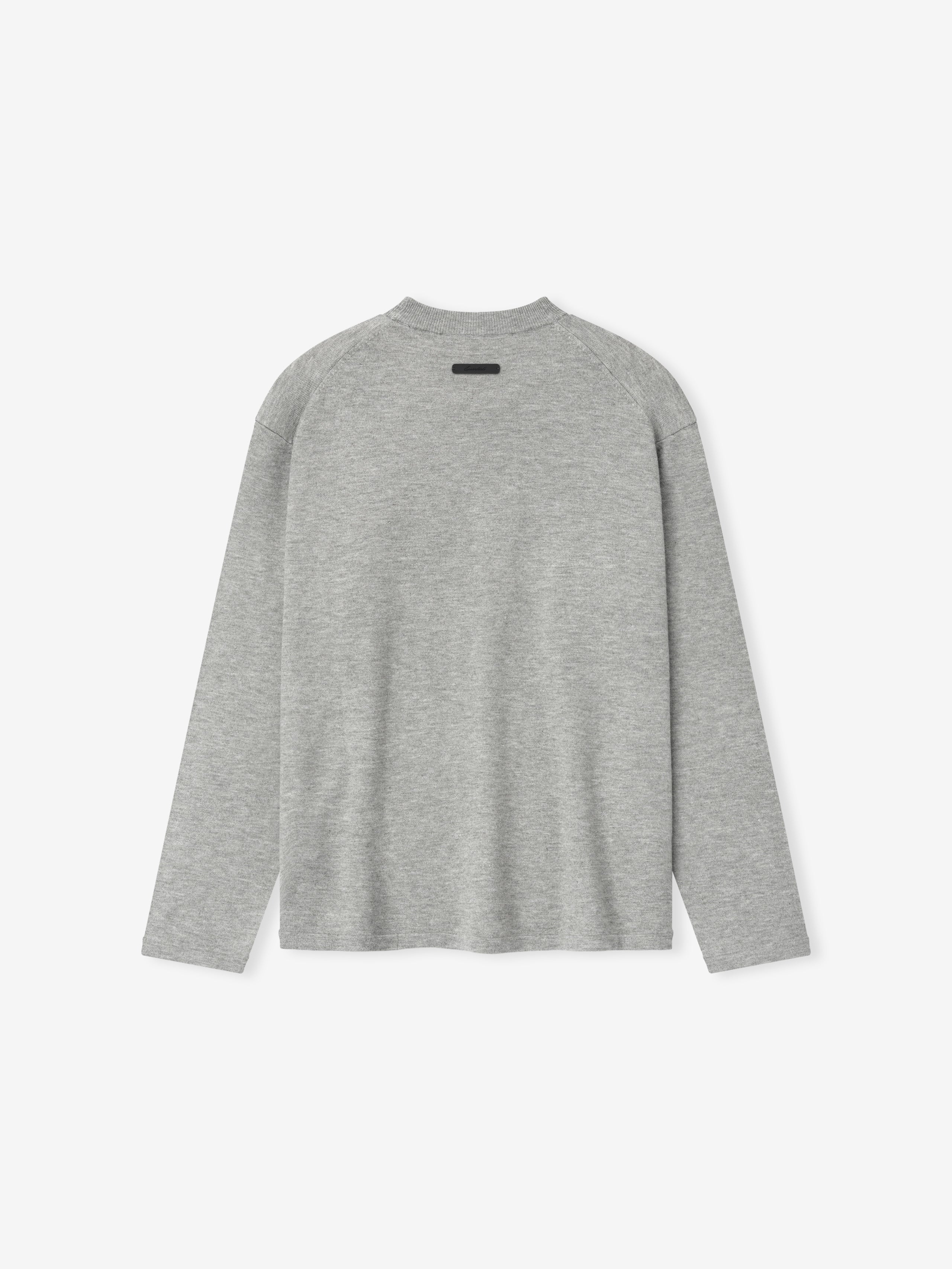 back view of light grey fitted knit long sleeve tee with relaxed silhouette and subtle Essentials label at neckline
