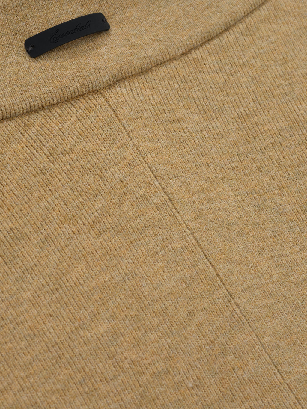 close-up of tan soft rib knit fabric and seam detail on women's rib knit bike shorts with Essentials logo tab
