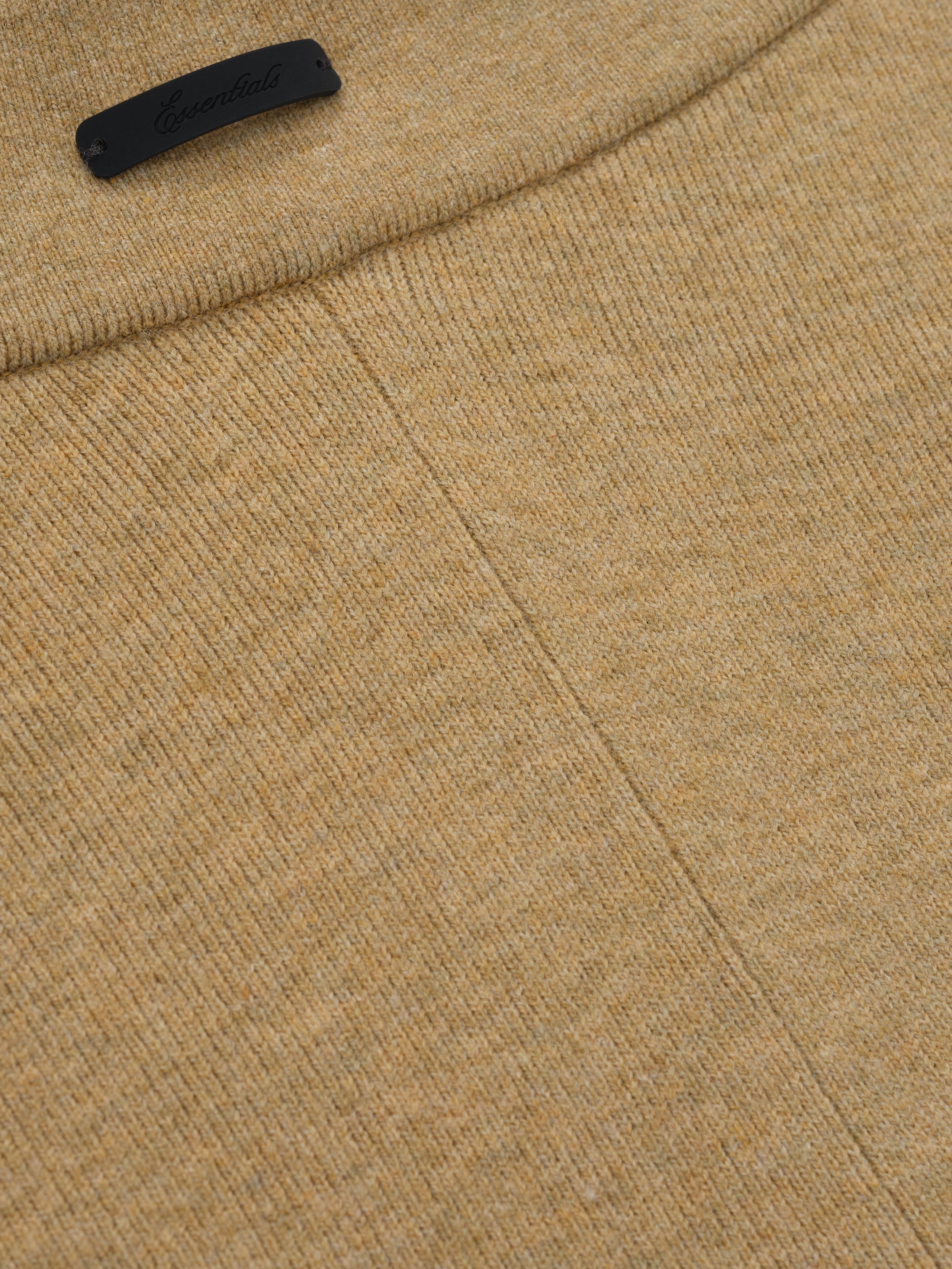 close-up of tan soft rib knit fabric and seam detail on women's rib knit bike shorts with Essentials logo tab
