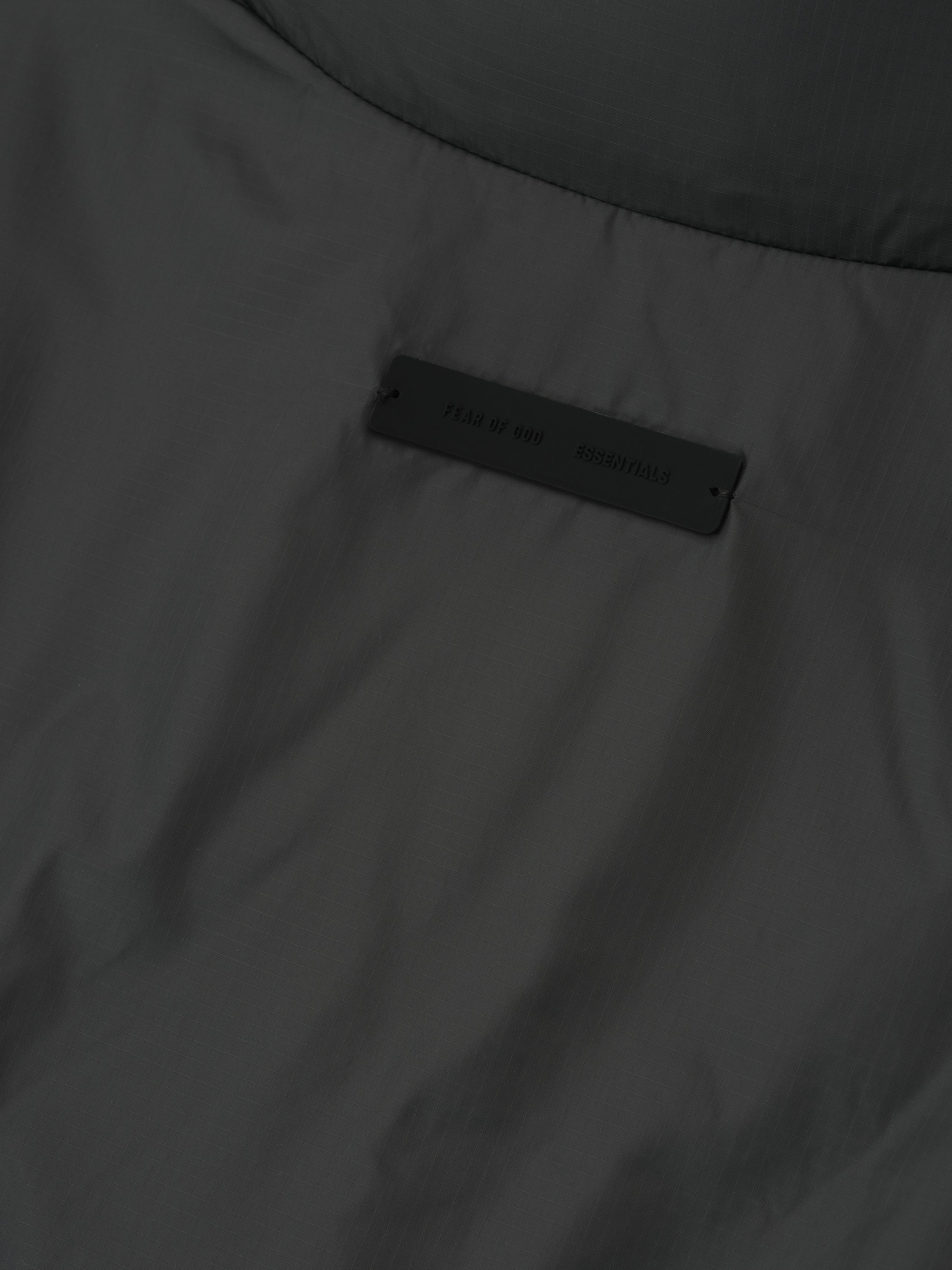 Close-up of iron grey ripstop nylon puffer jacket fabric showing subtle texture and branded label, file 202HO258151F.