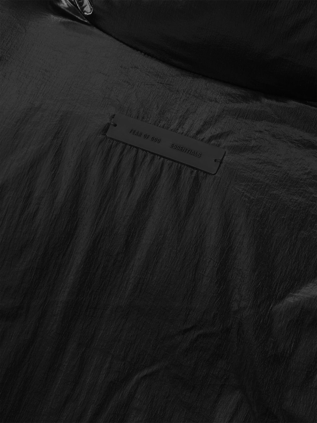 Close-up detail of metallic black ripstop nylon puffer jacket with branded label, file 202HO258181F, gallery position 0