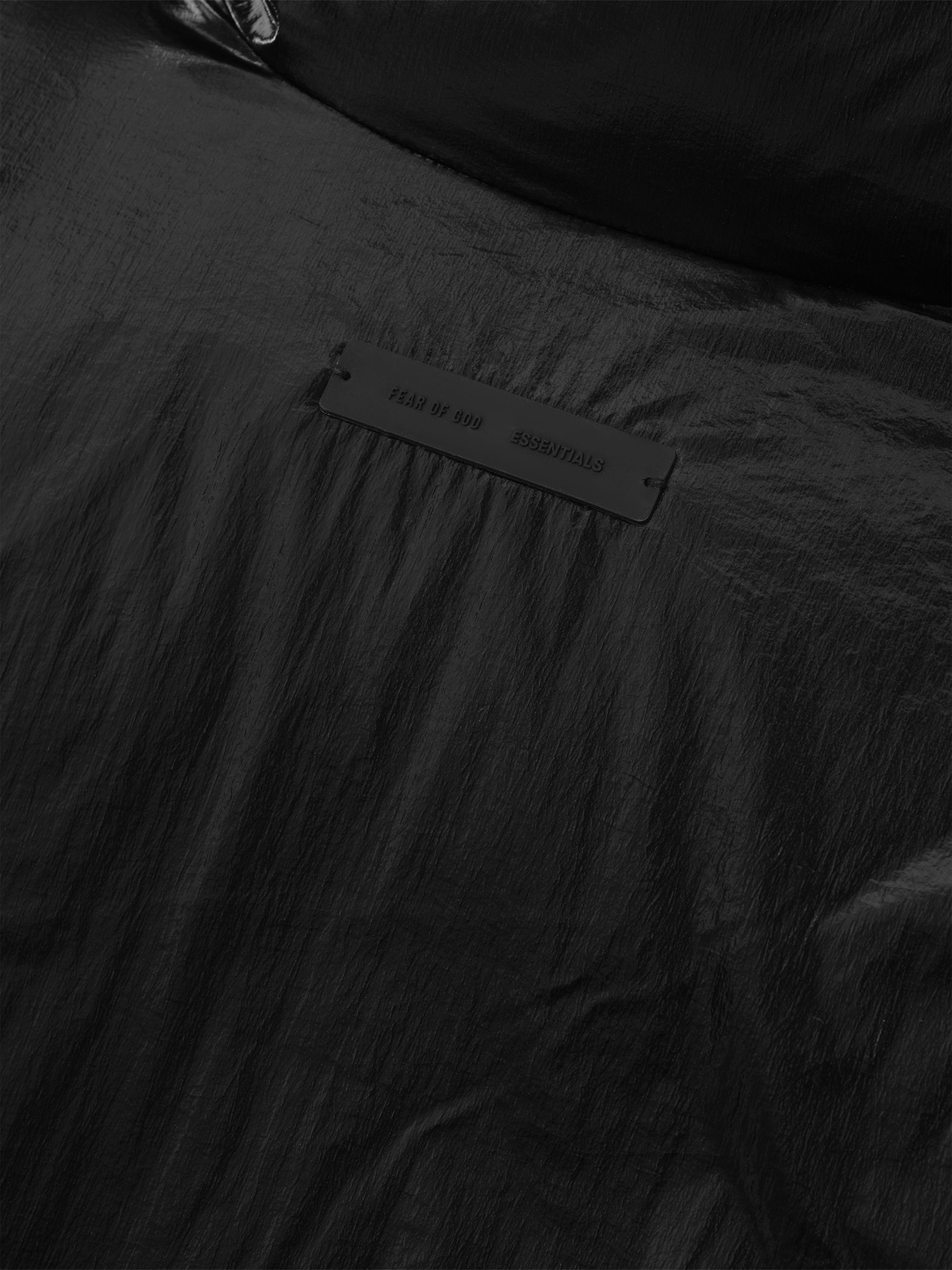 Close-up detail of metallic black ripstop nylon puffer jacket with branded label, file 202HO258181F, gallery position 0